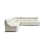 Sleek cream textured fabric L-shaped four-seater sectional sofa. Modern channel tufting and cozy comfort ideal for contemporary living rooms.